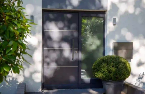 Haustür aus Metall mit Glaselement und großem Edelstahlgriff
