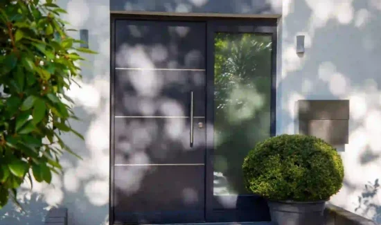 Haustür aus Metall mit Glaselement und großem Edelstahlgriff