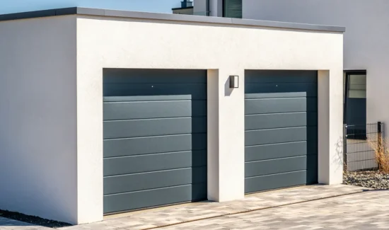 Einzelgarage mit grauem Sektionaltor als Anbau an ein Einfamilienhaus