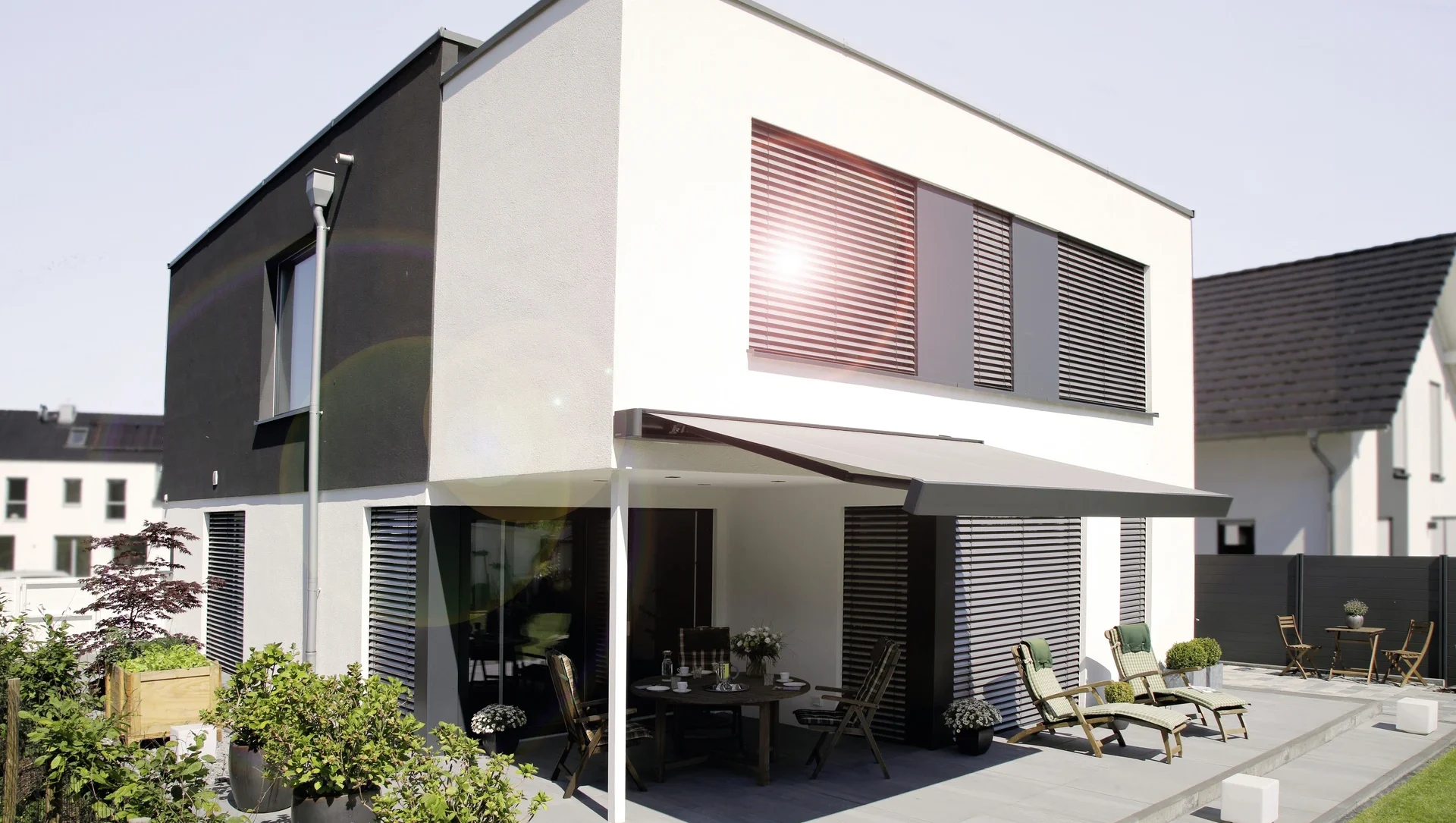 Modernes Einfamilienhaus mit Sonnenschutz und Terrasse